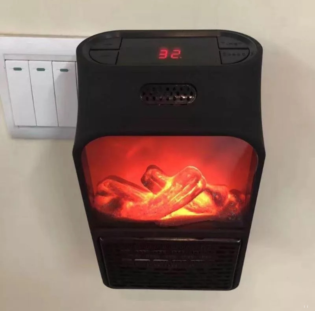 Mini Calefactor Eléctrico 900W Portátil Pantalla Digital 🌡️ Imagen principal del mini calefactor electrico 900w portatil con pantalla simulador hoguera conectado a un enchufe de pared mostrando el marcador digital a treinta y dos grados