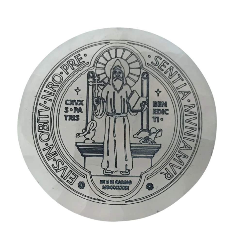 Detalle del grabado de la medalla de San Benito sobre plato de selenita natural blanca