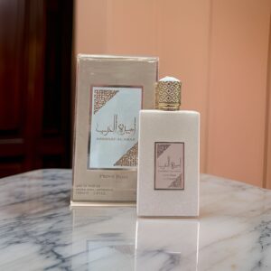 Fotografia real del perfume arabe ameerat al arab prive rose de cien mililitros de la marca asdaaf lattafa mostrando su frasco aterciopelado rosa con tapon dorado junto a su caja dorada sobre una mesa de marmol blanca