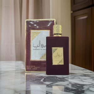 Fotografia real del perfume arabe ameerat al arab rojo de cien mililitros de la marca lattafa mostrando su frasco rectangular de terciopelo rojo con tapon dorado junto a su caja de lujo