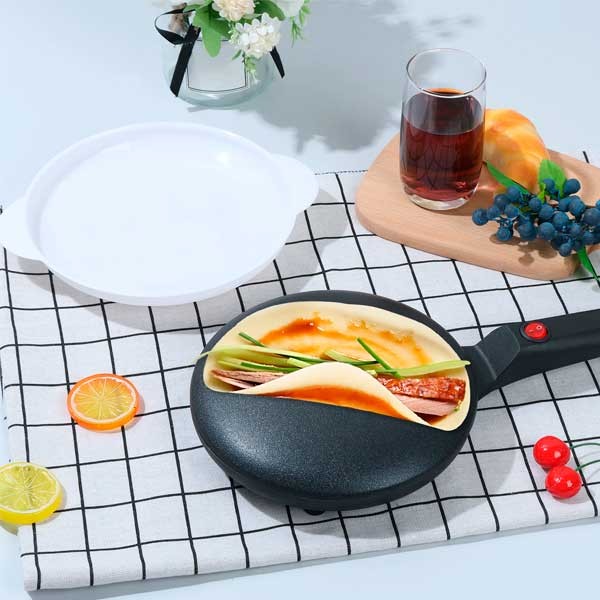 Uso de Crepera Eléctrica Sokany SK-5208 🍽️ Crepera electrica portatil Sokany SK-5208 sobre un mantel de cuadros preparando un crepe relleno junto a un plato de masa y un vaso de bebida