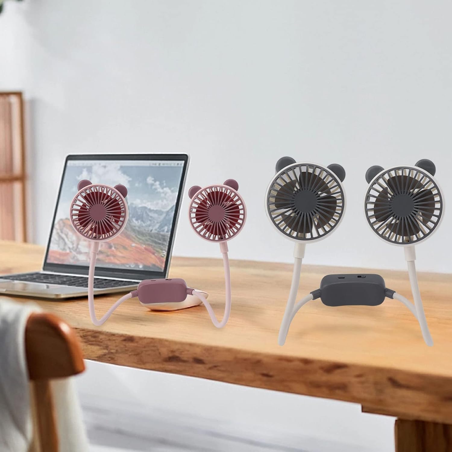 Ventilador ExtraHouse FSF5583 en Modo Escritorio 💻 Dos unidades del ventilador de cuello portatil ExtraHouse FSF5583 en colores gris y rosa colocados de pie sobre una mesa de madera junto a un ordenador portatil