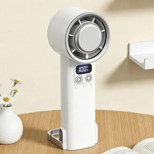 Ventilador portatil turbo marca raptor modelo zs-616 de color blanco sobre una mesa de madera al lado de un florero con margaritas